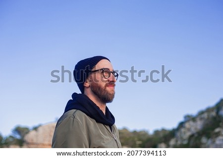 portrait handsome man at the edge of a cliff of the Mediterranean sea winter sunny day