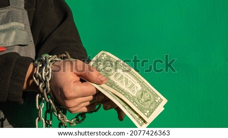 a chained contractor with money in his hands. an employee who has received a salary for services. advertising picture. space for printing.