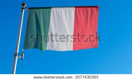National flag of Italy waving in the wind over blue sky. Diplomacy concept. International relations. Space for text.