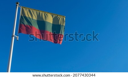 National flag of Lithuania on a flagpole in front of blue sky with sun rays and lens flare. Diplomacy concept. International relations. Space for text.