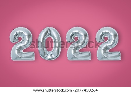 silver color Christmas 2022 balloons isolated on pink background.