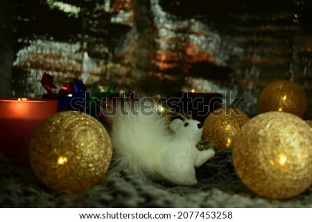 Christmas still life with a ceramic figurine of a penguin in a knitted hat, a garland in the form of balls woven from threads. 