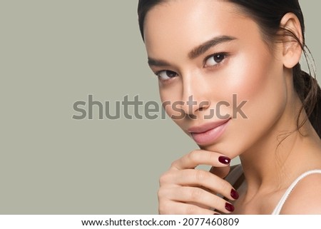 Beautiful woman close up face asian girl with clean fresh healthy skin. Color background. Green
