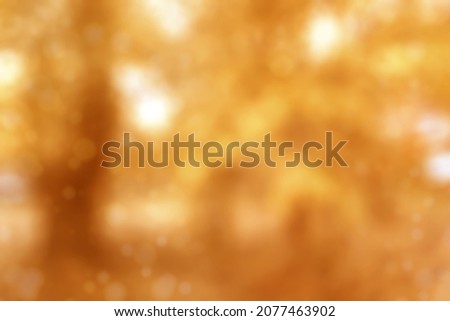 Blurred fall nature background in brown tones. Autumn foliage on trees over sun light in garden or park.