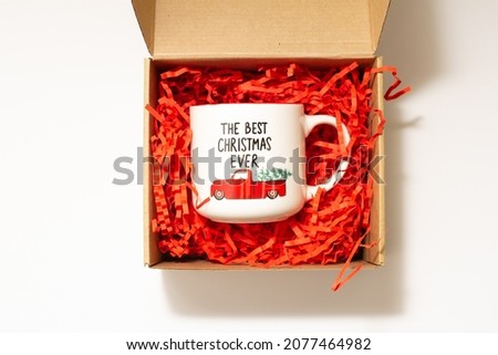 white mug with christmas lettering in a gift box, package