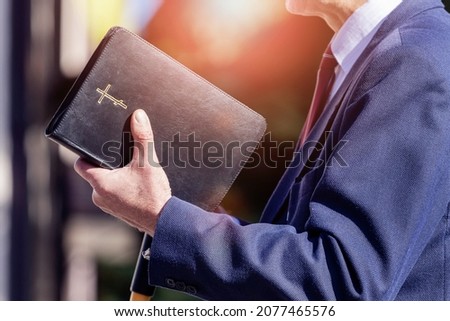 Pastor with a Bible in his hand during a sermon. The preacher delivers a speech Royalty-Free Stock Photo #2077465576