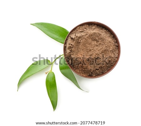 Dry henna powder in bowl on white background