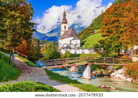 Ramsau bei Berchtesgaden, Germany. Autumnal scenery of Ramsau National Park in Berchtesgadener Land in Bavaria with incredible seasonal view of Parish Church of St. Sebastian and River Ramsauer Ache. Royalty-Free Stock Photo #2077478920
