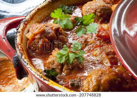 Meatballs casserole in red iron crock pot. Royalty-Free Stock Photo #207748828