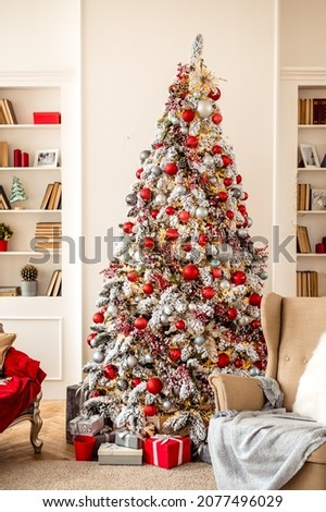 Cozy decor for Christmas and New Year. New Year's concert. Christmas photo. A photo zone with Christmas landscapes: a Christmas tree, gifts, an armchair with pillows and bookshelves.