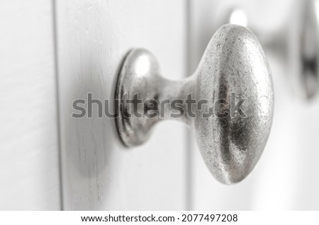 Close up of crome knobs on painted kitchen, wardrobe doors. Interior object photo