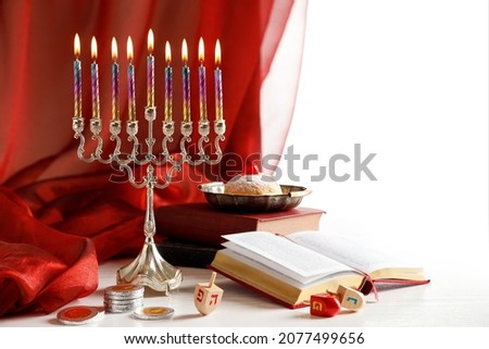 Day 8 of Jewish religious holiday Hanukkah with holiday Hanukkah (traditional candelabra), spinning top toys (dreidels), doughnut, chocolate coins and Religious books (Tanakh)