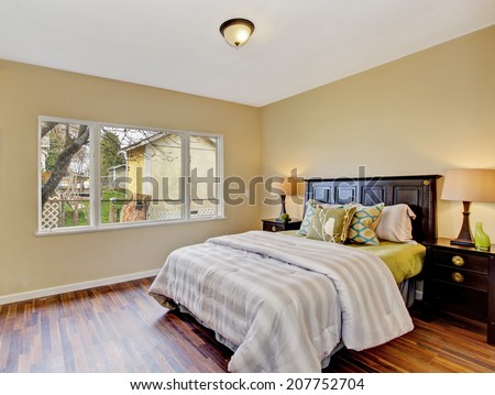 Light tones bedroom interior with hardwood floor and dark brown furniture