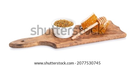 Bowl of bee pollen and honey combs on white background Royalty-Free Stock Photo #2077530745