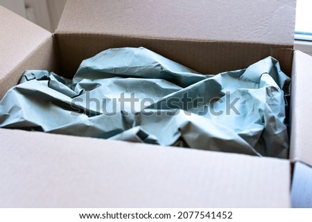 Close-up of a cardboard box with packed glasses. The concept of moving, collecting things. The concept of ecological packaging, moving in an office, in an apartment, repairing and collecting things