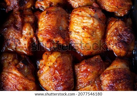 Roasted chicken thighs background. Baked chicken parts lies on flat surface and fill the whole frame of picture. Close up. top view