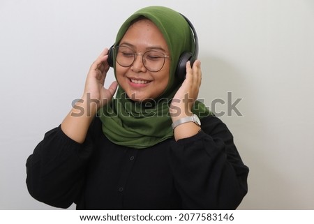 Isolated Photo of Beautiful Hijabi Woman Smile while Listening Headphone