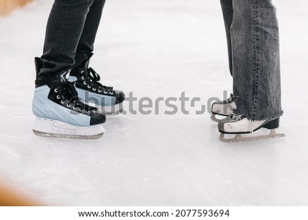 Photo of young couple holding their hands in and figure skating foot shot