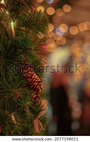 festive atmosphere evening street warm December holidays eve time vertical photography, background bokeh lights, foreground cone decorative soft focus object 