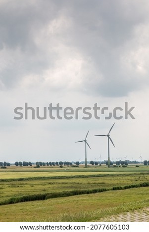 Wind wheels for renewble energy on the flat marshland of North Germany Royalty-Free Stock Photo #2077605103