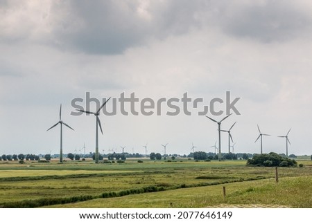 Wind wheels for renewble energy on the flat marshland of North Germany Royalty-Free Stock Photo #2077646149
