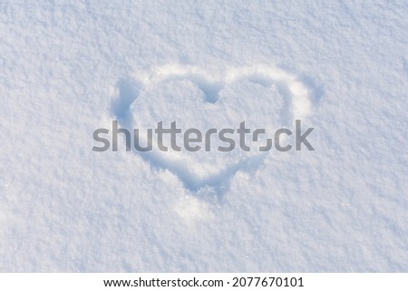 A heart shape squeezed into the white snow. The basis for the postcard. Place for an inscription
