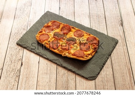 Pepperoni is an American variety of salami, made from cured pork and beef mixed and seasoned with paprika or other chili, characteristically mild, lightly smoked, and bright red in color.