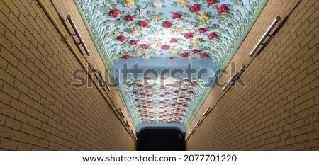 Beautiful floral ornament on the ceiling of the arch on the street. Bright flower molding. Beautiful flower decorations. Floral pattern.