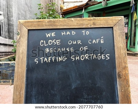Staffing shortages sign at closed business due to lack of staff, employee shortage Royalty-Free Stock Photo #2077707760