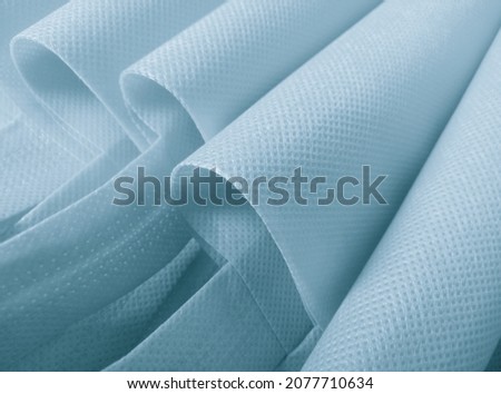 light blue polypropylene bag. non-woven fabric with wavy pleats. pile of environmentally friendly bag materials. spunbond bag Royalty-Free Stock Photo #2077710634