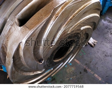 
a centrifugal pump impeller is placed in a standing position awaiting installation on a pump that is still under repair in the shop Royalty-Free Stock Photo #2077719568