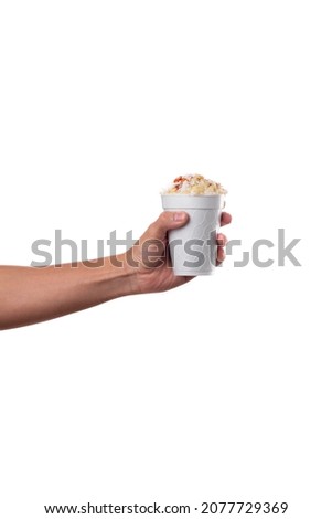 a corn in a cup, esquite, with cheese and chili, held by a hand with a white background, fast food Royalty-Free Stock Photo #2077729369