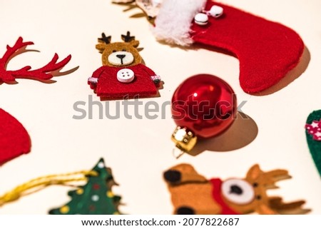 Detail of Christmas decorations with reindeer, gingerbread man, socks and Christmas ball, snowflake and penguin decorations on pastel background. Christmas concept, decorations and celebration.