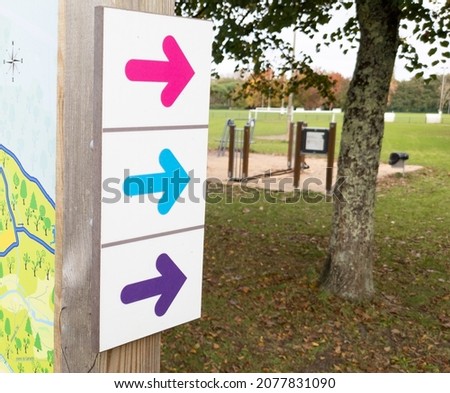 wooden arrow colorful pointing the direction of footpath for hike trail escape city path in park