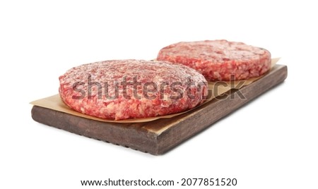 Raw hamburger patties and wooden board on white background