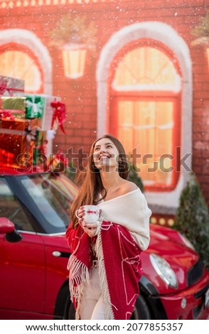 Beautiful young woman in winter with long dark in trendy winter outfit with gifts for Christmas