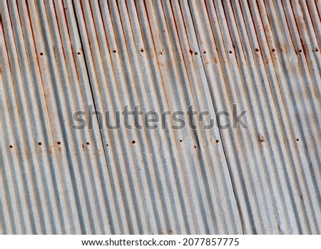 Old galvanized roof background blur in vintage style for your graphic design or wallpaper. Rusty wall texture on sheet metal in retro concept.