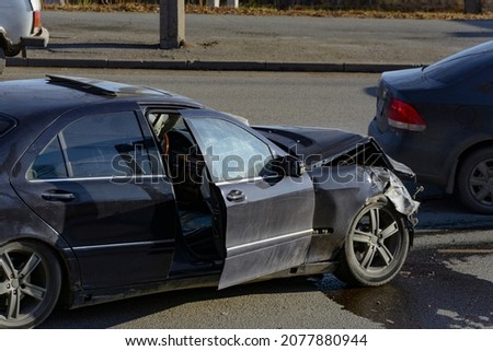 a black passenger sedan stopped after a serious accident with a broken hood and a triggered airbag. fuzzy focus Royalty-Free Stock Photo #2077880944
