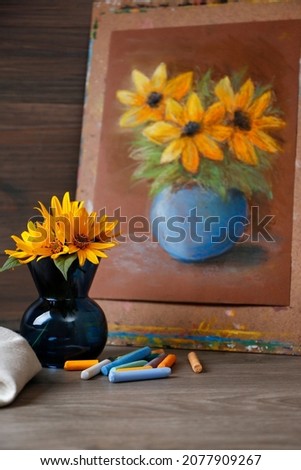 Yellow flowers, beautiful drawing and set of colorful pastels on wooden table