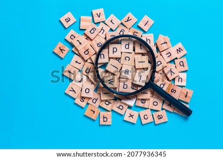 English alphabet made of square wooden tiles with the English alphabet scattered on blue background. The concept of thinking development,grammar. Royalty-Free Stock Photo #2077936345