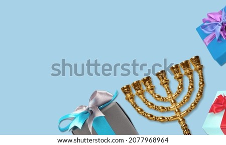 Jewish holiday Hanukkah background with a menorah and gift box on table