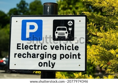 A sign indicating an electric vehicle recharging point or parking space in a car park