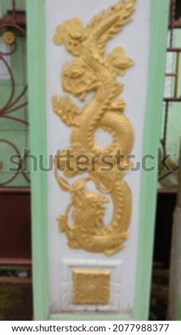 defocused abstract yellow dragon wall statue