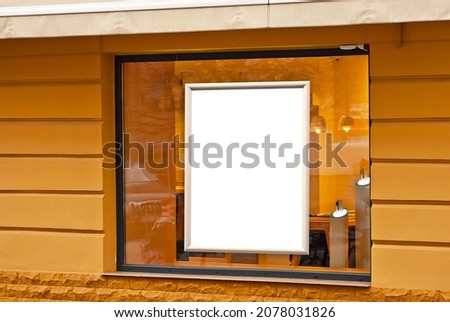Rectangular sign on the building. Copy space and space for text. Mockup for design. Blank template for advertising. White frame on a glass case. Advertising on the window of a restaurant or shop. Royalty-Free Stock Photo #2078031826