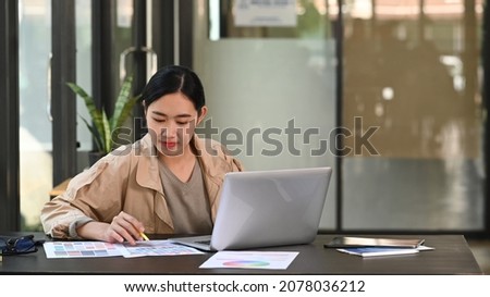 Thoughtful young female designer working in creative office.