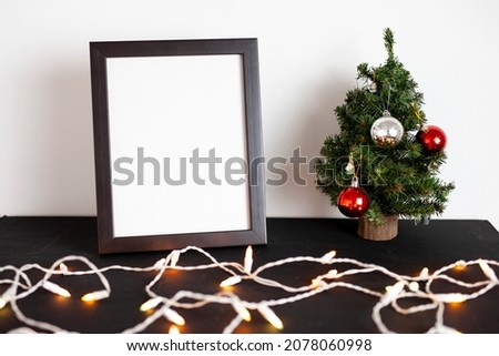 picture frame and christmas tree on a table with lights and decoration