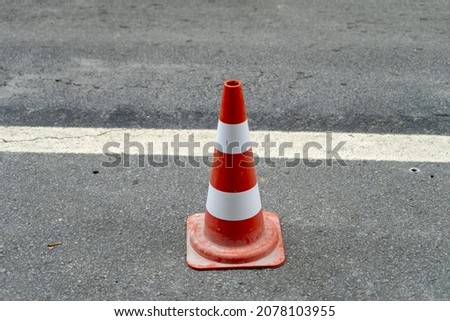 A red traffic cone on the street for a temporary diversion of traffic in a safe manner