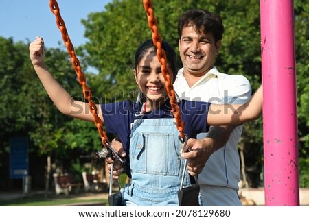 Happy father and daughter playing and enjoying together at public park