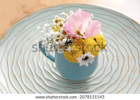 Beautiful bright flowers in light blue cup