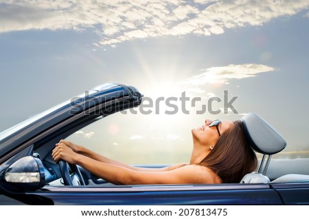 Portrait of Young girl driving cabriolet at sunset. Royalty-Free Stock Photo #207813475